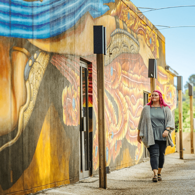 person walking by street mural in Downtown Fayetteville